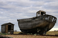 an old fishing boat and a wooden hut
