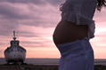 fishing boat and pregnant midriff against a dawn sky