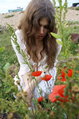 Girl in white lace among poppies