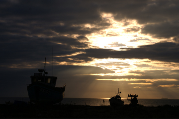 Fishing boats silhouetted against the first light of dawn