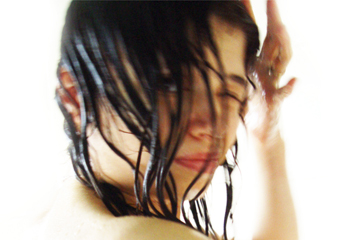 female in shower looking through wet hair