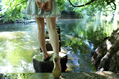Girl in short denim skirt and sandals on stepping stones across a stream
