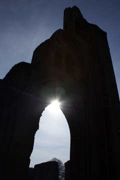 Sun shining through ruined Abbey arch