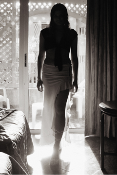 Female silhouetted and illuminated in balcony doorway