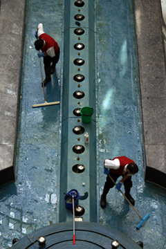 Two men sweeping coins out of a fountain